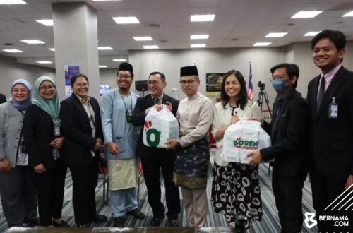 Datuk Fahmi Fadzil and Deputy Minister Teo Nie Ching distribute Borenos meal packs to media personnel at the Parliament Building during Malaysia’s Budget 2026 presentation.