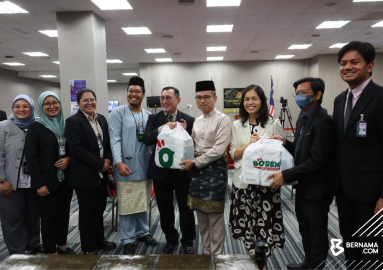 Datuk Fahmi Fadzil and Deputy Minister Teo Nie Ching distribute Borenos meal packs to media personnel at the Parliament Building during Malaysia’s Budget 2026 presentation.